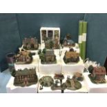 A collection of boxed Thomas Kinkade lamplight village houses from The Hawthorne Village