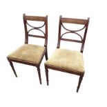 A pair of nineteenth century mahogany side chairs with ribbed back rails above channelled