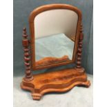 A Victorian dressing table mirror with arched cushion moulded frame on twisted columns above a