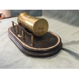 Trench art - a 1918 shell mounted on moulded ebonised plinth with a length of Somme barbed wire