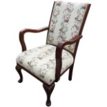 An oak framed armchair with upholstered back and shaped arms above a sprung seat, raised on cabriole