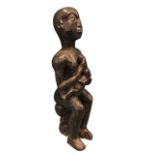 A carved hardwood figure of a seated mother & child, formed from one piece. (20in)