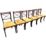 A set of six regency style mahogany dining chairs, the brass inlaid top rails above crossed