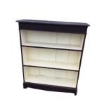 A painted open bookcase with rectangular moulded top above a plain frieze and three open shelves,