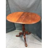 An oval Victorian mahogany table, formerly with drop leaves, the moulded top supported on a baluster