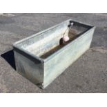 A rectangular galvanised water trough with tubular rim, fitted with ballcock valve. (48in x 19in x