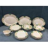 A Booths dinner service with buttercup and green scale scrolled decoration, having three graduated