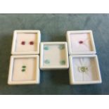 A collection of boxed gemstones - a pair of rubies, a pair of Brazilian pear cut emeralds, four oval