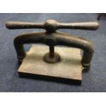 A Victorian cast iron press with rectangular plate beneath an arch, the screw mechanism with waisted