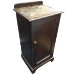 A stained Edwardian mahogany pot cupboard with shaped upstand above a rectangular moulded top,