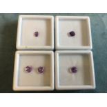 A collection of loose boxed amethysts - a pair of pink heart-cut of approx 2 carats, a round cut