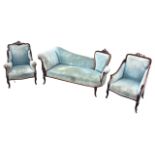 A late Victorian carved mahogany salon suite, the chaise style sofa with waisted chair back, the