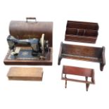 A domed cased Hexagon cast iron sewing machine; two book troughs - oak & mahogany; a mahogany