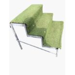 A set of galvanised steps with three treads on square supports, covered in artificial turf. (35in