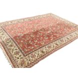 An oriental style Axminster carpet with multi-floral pink field framed by ivory border of linked