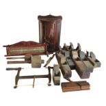 A collection of old tools - planes, mallets, a spokeshave, a saw, etc; a D-shaped glazed mahogany