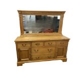 A reproduction pine sideboard, the mirrored back with rectangular moulded frame beneath dentil