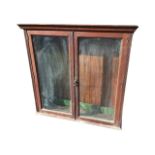 A glazed late nineteenth century oak wall cupboard with moulded cornice above pair of glass doors,