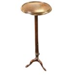 A mahogany jardiniere stand with circular tray top on turned tapering column above a fluted