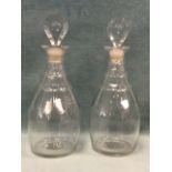 A pair of antique mallet shaped decanters with petal shaped stoppers, having faceted cut