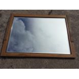 A large oak framed mirror with rectangular bevelled plate, the sides with applied fluted