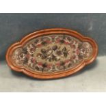 A Victorian floral beadwork panel under tray glass in scalloped moulded quatrefoil shaped mahogany