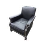 A leather upholstered armchair, with padded back and arms with brass studding, having loose