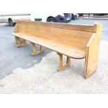 A long Victorian pine pew, the back with rounded moulded rail, supported on chamfered shaped ends,