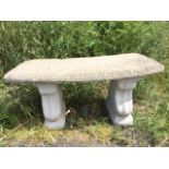 A crescent shaped composition stone bench, the top cast with leaf frieze, raised on rectangular