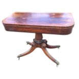 A George IV mahogany turn-over-top tea table, the D-shaped crossbanded top with ebony stringing,