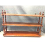 A set of nineteenth century stained wall shelves with three rounded platforms supported by turned