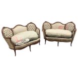 A pair of Louis XV style carved canapés, the serpentine shaped backs with button upholstered