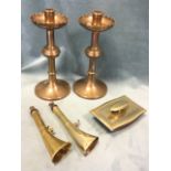 A pair of brass candlesticks with scalloped saucer drip-trays to columns; a brass desk blotter;