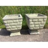 A pair of square composition stone garden planters with moulded rims, cast with brick style sides on