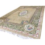 A thick-pile wool rug woven with fawn field having central oval floral medallion, and corners with