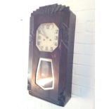 A deco wallclock in floral carved oak case, the octagonal silvered dial above a glazed pendulum