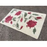 An Indian Phoenox wool rug woven with red vines on cream ground. (59in x 36in)