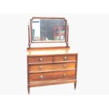 A George VI oak dressing table, the rectangular bevelled mirror on turned column supports with urn