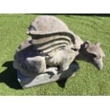 A composition stone wyvern, the winged creature with coiled tale on rectangular plinth. (21in)