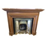 A reproduction chimneypiece, the pine surround with mantleshelf on moulded dentil cornice above an