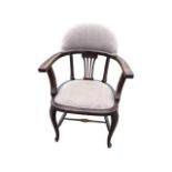 A C20th upholstered captains chair with arched back above a pierced splat, having bow arms on shaped