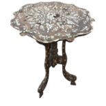 A circular eastern carved table inlaid with mother-of-pearl leaves and flowers to scalloped top,