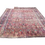 An antique Isphahan carpet woven with floral field on red ground framed by ink blue floral frieze