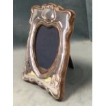 An art nouveau hallmarked silver photo frame with heart shaped aperture, on easel stand. (7.5in)