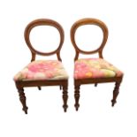 A pair of Victorian mahogany balloon back chairs, with upholstered seats on turned tapering legs. (