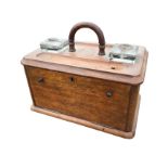 A Victorian oak desk tidy, the box having top with arched handle, glass inkwells and pentrays, above