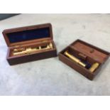 A mahogany cased brass table microscope with spare lenses/pieces; and another mahogany box with