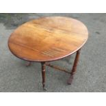 A Victorian walnut sutherland table with two rounded drop leaves forming an oval moulded top,