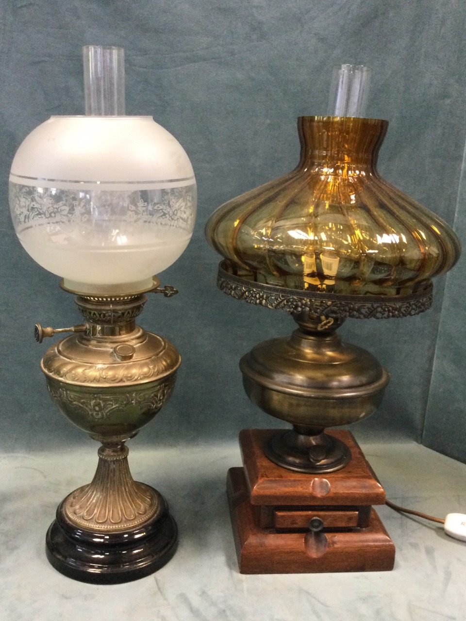 A Victorian brass oil lamp with embossed reservoir on fluted base mounted on glazed stand, fitted