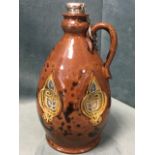 A Royal Doulton stoneware flagon decorated with recessed floral scrolled panels on leather brown